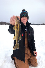 A student holds a fish caught while ice fishing